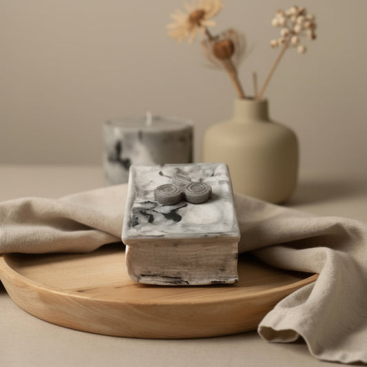 A heavy marble concrete container shaped like a vintage spellbook. Filled with snowy sand wax and topped with artisanal HP melts, it’s the ultimate centerpiece.