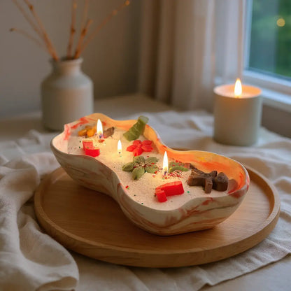 Festive Christmas sand wax candle with tree and gingerbread wax toppers in a red marble container