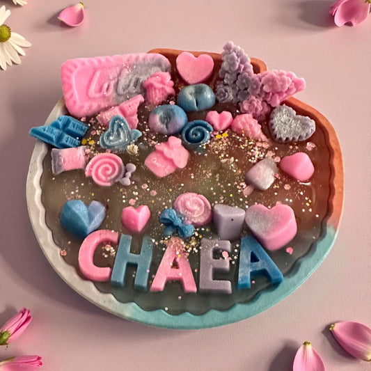 Fully customized birthday candle with personalized name, resin shell, and colorful wax melt toppers