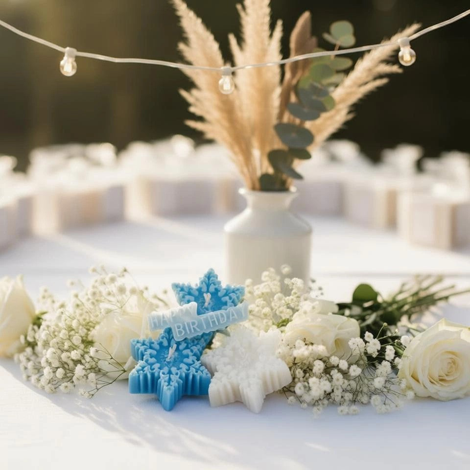 Decorative setup with blue 'BIRTHDAY' cake toppers, white flowers, and a vase on a table outdoors.